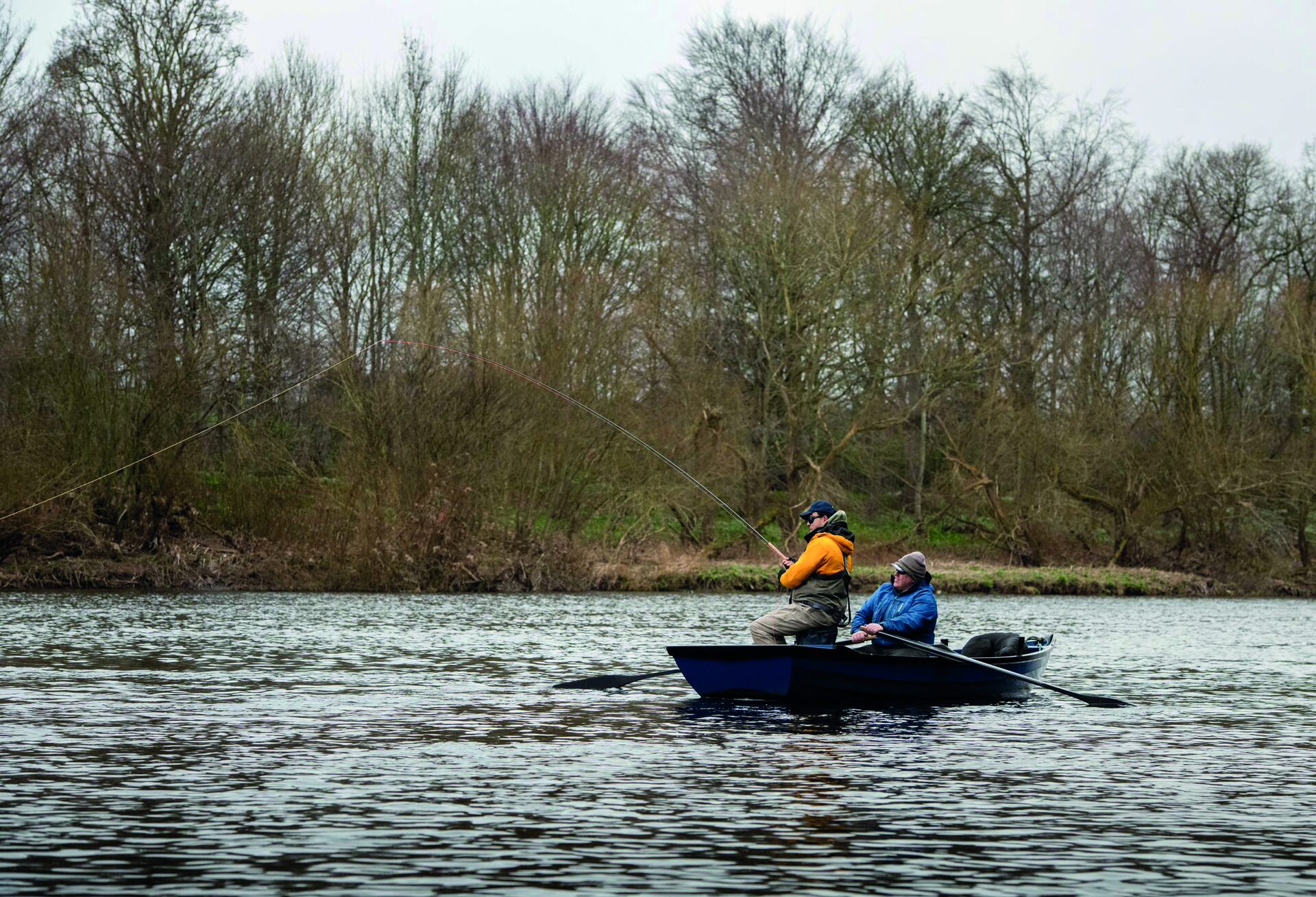 Two anglers fishing from a boat on the River Tweed at Upper North Wark