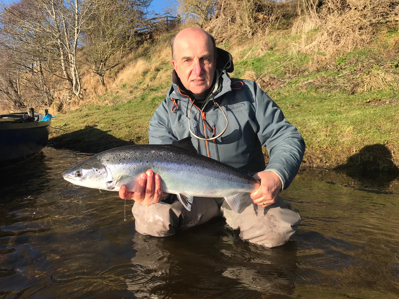 An angler holding a caught salmon