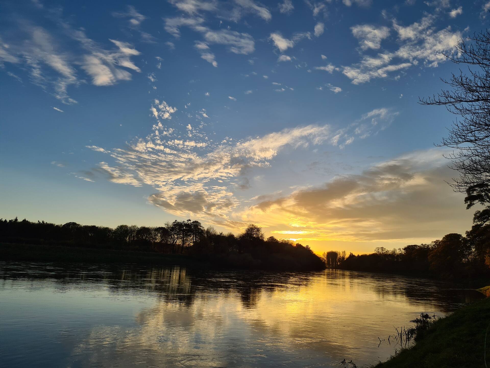 Sunset over the River Tweed with clouds reflected in still water